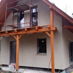 Fasad Servis - Dom jednorodzinny w trakcie prac elewacyjnych, widoczne rusztowania i świeżo nałożony tynk strukturalny na ścianach zewnętrznych.