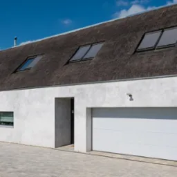 Nowoczesny dom z białym tynkiem, strzechą na dachu, oknami dachowymi z roletami i białą bramą garażową segmentową, numer posesji 22.