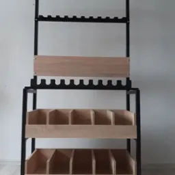 Metalowy regał z drewnianymi półkami i przegródkami w jasnym odcieniu dębu, przeznaczony do przechowywania butelek lub innych przedmiotów, z widocznymi elementami mocującymi.