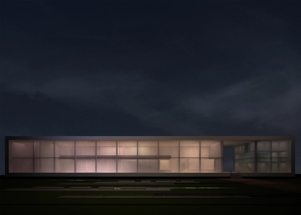 Nowoczesny budynek biurowy oświetlony nocą, z minimalistyczną fasadą i rozległym trawnikiem z elementami dekoracyjnymi.