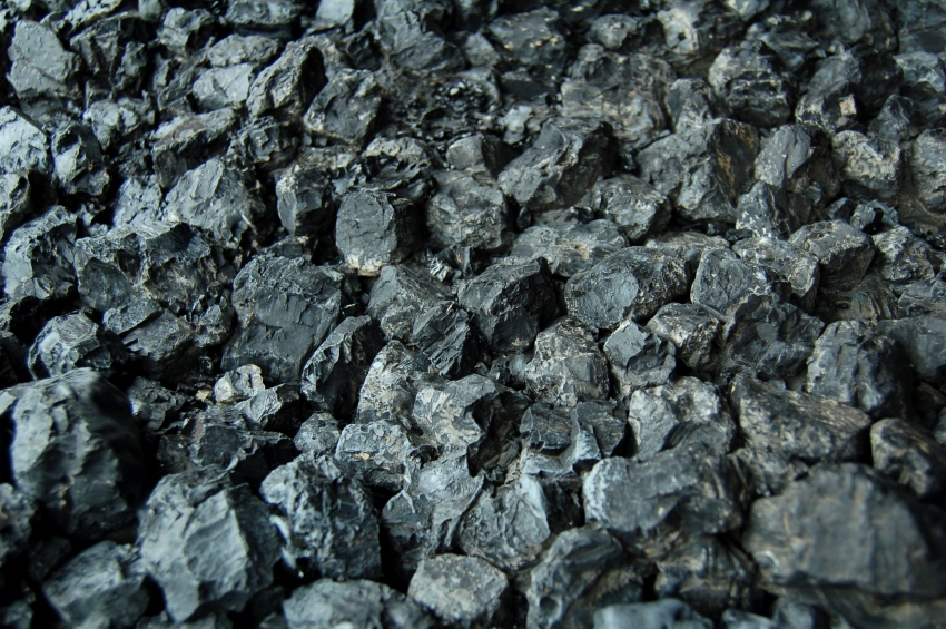 Góra ekogroszku o nieregularnych kształtach, z widocznymi refleksami światła na powierzchni bryłek.