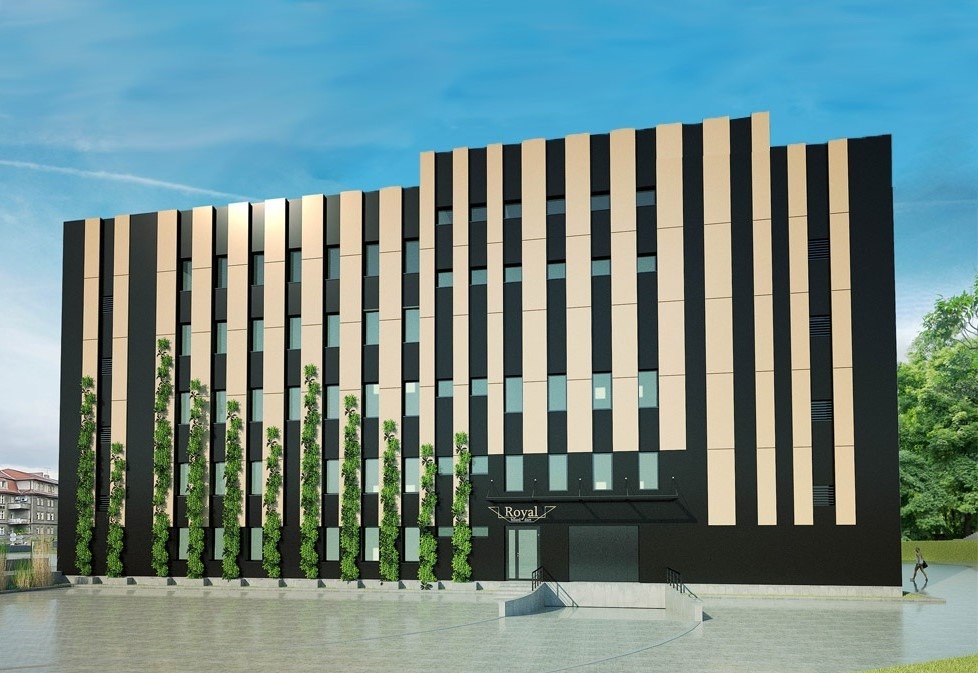 Nowoczesny budynek biurowy Royal z czarno-beżową fasadą, pionowymi pasami i zielonymi pnączami. Błękitne niebo w tle, osoba w oddali.