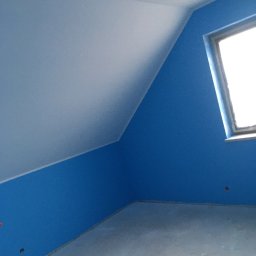 Deco-Bor Tomasz Borkowski - Pokój na poddaszu z pomalowanymi na niebiesko ścianami, biały sufit ze skosem, okno z taśmą malarską na framudze, widoczne niedoskonałości wykończenia przy podłodze.