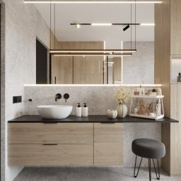GES STUDIO Wykończenia wnętrz Sylwia i Wiktor Gęs - Nowoczesna łazienka z kamienną ścianą, okrągłą umywalką nablatową, drewnianą szafką z czarnym blatem, podświetlanym lustrem i szarym stołkiem na cienkich nogach.