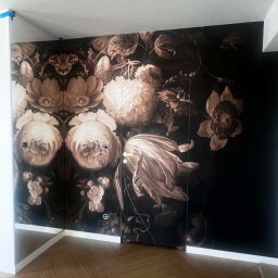 GES STUDIO Wykończenia wnętrz Sylwia i Wiktor Gęs - Szafa wnękowa z fototapetą w kwiaty w odcieniach sepii, parkiet w jodełkę, białe listwy przypodłogowe. Widoczne niebieskie taśmy malarskie na suficie.