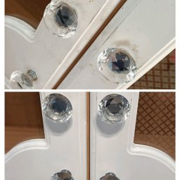 F.U BLASK CZYSTOŚCI PAULINA CHĄDZYŃSKA - Białe, drewniane drzwiczki szafki z kryształowymi gałkami, widoczne ślady kurzu i zabrudzeń na powierzchni.