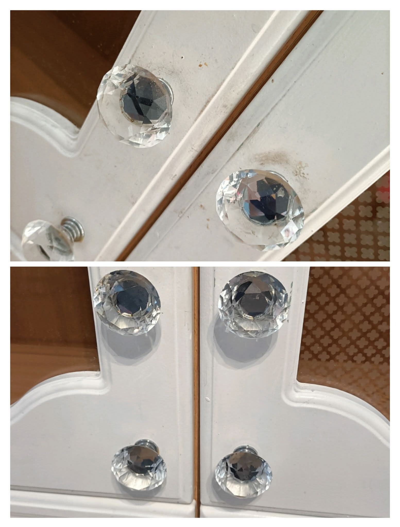 Białe, drewniane drzwiczki szafki z kryształowymi gałkami, widoczne ślady kurzu i zabrudzeń na powierzchni.