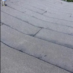 Nowo położony, płaski dach pokryty papą bitumiczną z widocznymi łączeniami i elementami wentylacyjnymi.