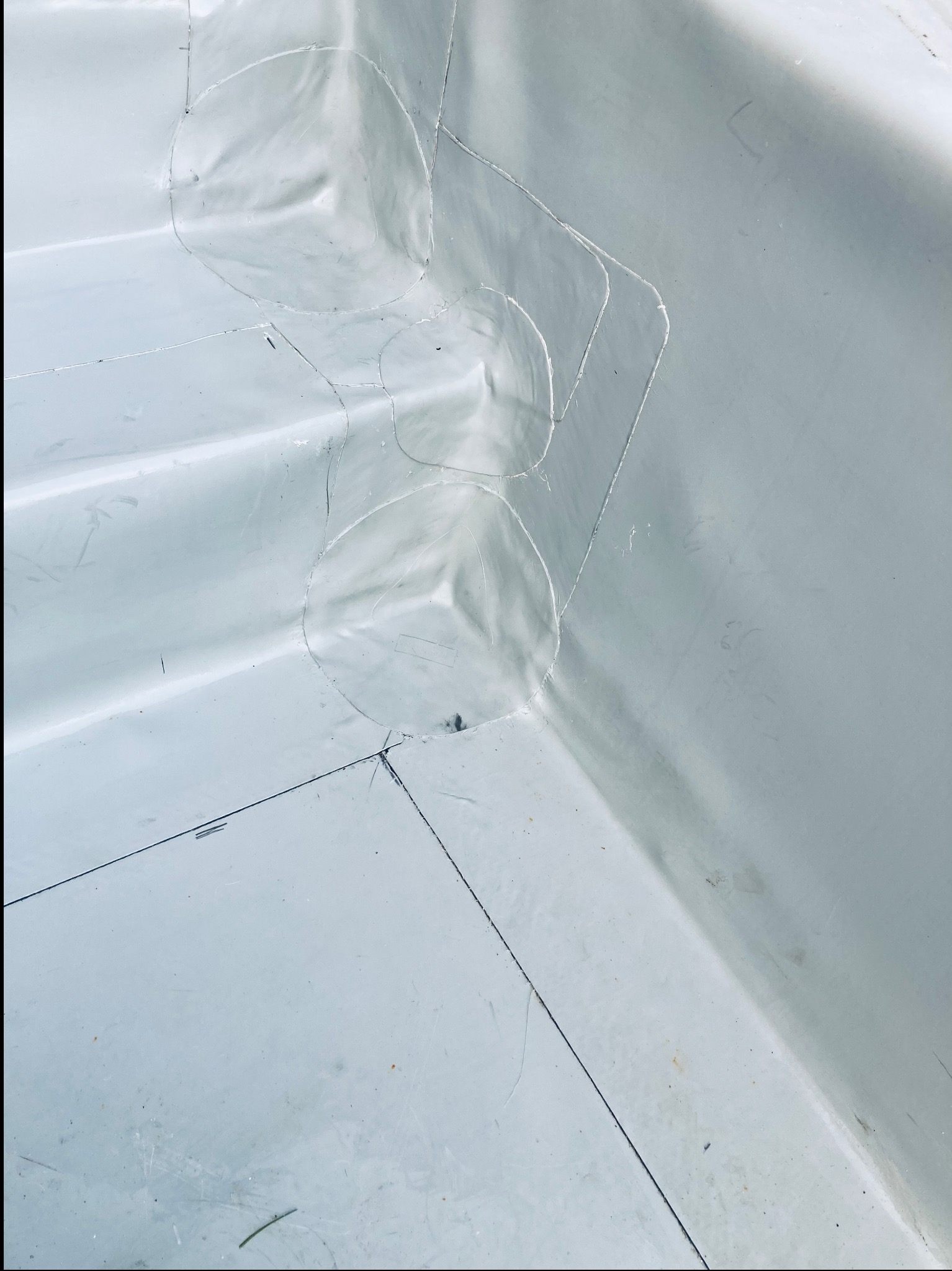 Szczegółowe ujęcie fragmentu dachu z widocznymi obróbkami blacharskimi wokół komina, wykonanymi z jasnoszarej blachy, z widocznymi śladami po ołówku i nitach.