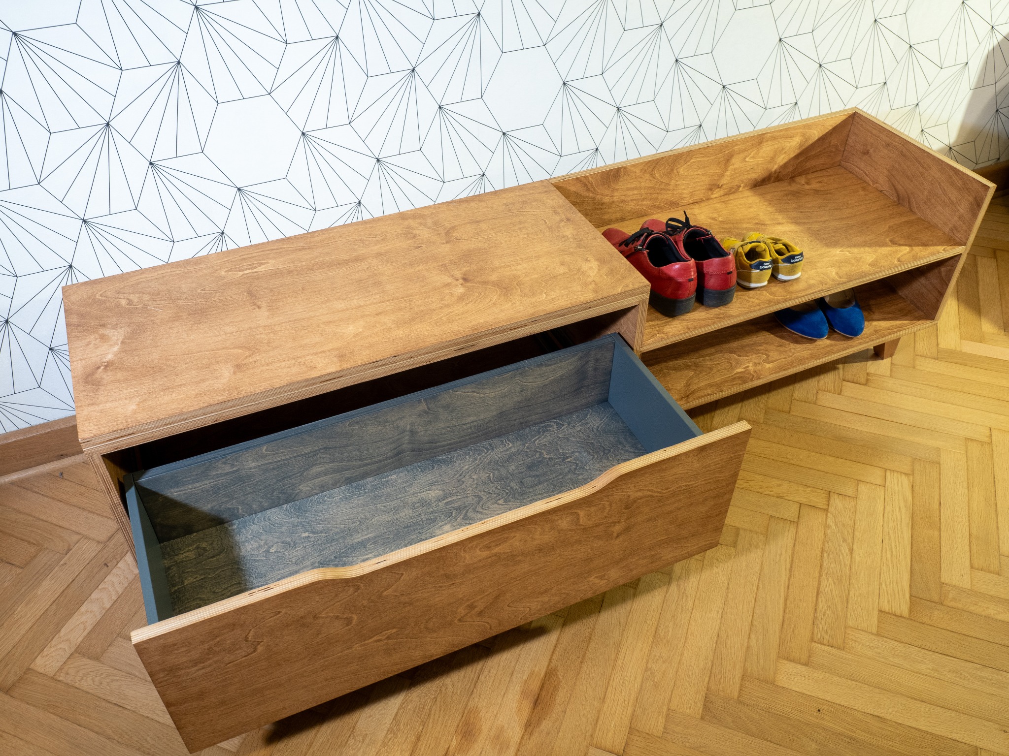 Szafka na buty z siedziskiem wykonana ze sklejki, wykończona bejcą olejną i olejowoskiem.