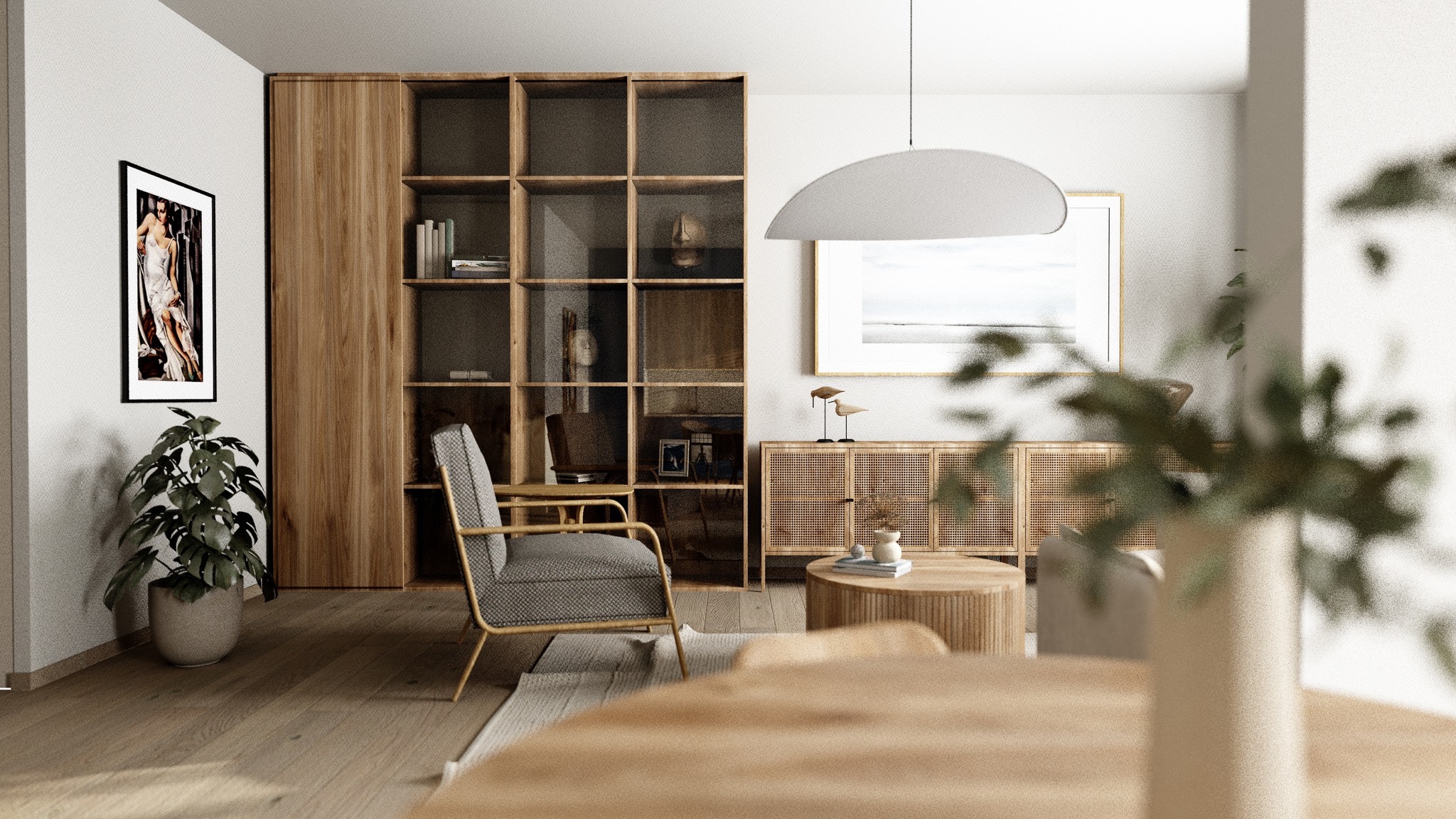 Jasne wnętrze salonu z drewnianymi meblami: regał z otwartymi półkami, komoda z rattanowymi frontami, okrągły stolik kawowy i fotel z szarą tapicerką, uzupełnione o rośliny doniczkowe i grafiki...