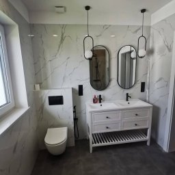 PPHU Solid Kuchnia Andrzej Tarwid - Nowoczesna łazienka z marmurowymi płytkami, podwójną białą umywalką z szafką i czarnymi akcentami: baterie, oświetlenie i armatura toalety.