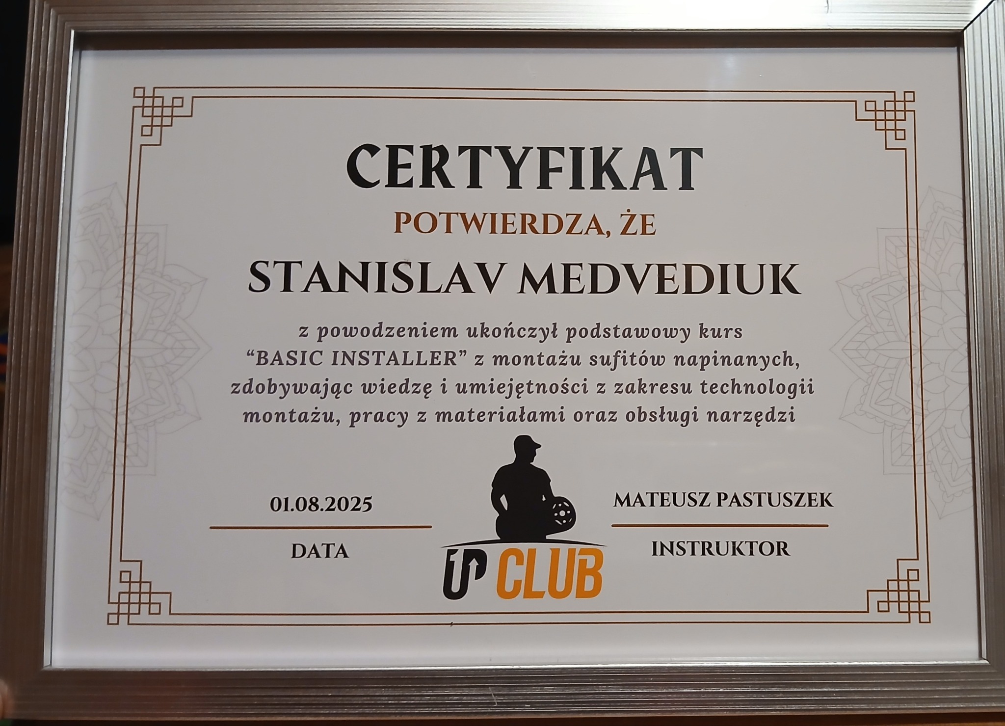 Certyfikat ukończenia kursu 'BASIC INSTALLER' przez Stanisława Medvediuka, potwierdzający wiedzę z zakresu montażu sufitów napinanych, oprawiony w srebrną ramkę.