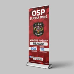 Roll-up reklamowy z grafiką i logo Ochotniczej Straży Pożarnej Sucha Wieś, zawierający numery alarmowe 998 i 112 oraz hasło 'Widzisz pożar? Reaguj!'.