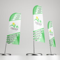 Mikołaj Stępień - Trzy beachflagi reklamowe z logo i danymi kontaktowymi agroturystyki Zacisze, prezentujące ofertę na Airbnb, Booking i Facebook, ustawione na szarym tle.