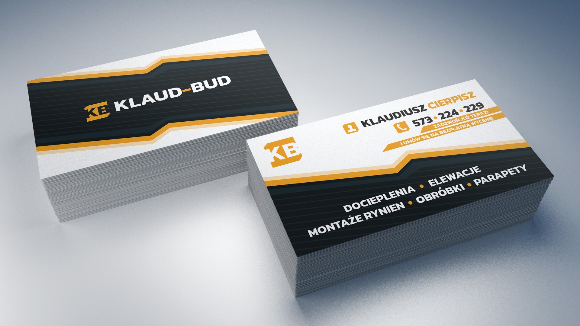 Stos wizytówek firmy budowlanej z logo KB KLAUD-BUD w kolorach czerni, bieli i pomarańczu, prezentujących dane kontaktowe i zakres usług: docieplenia, elewacje, montaże rynien, obróbki, parapety.
