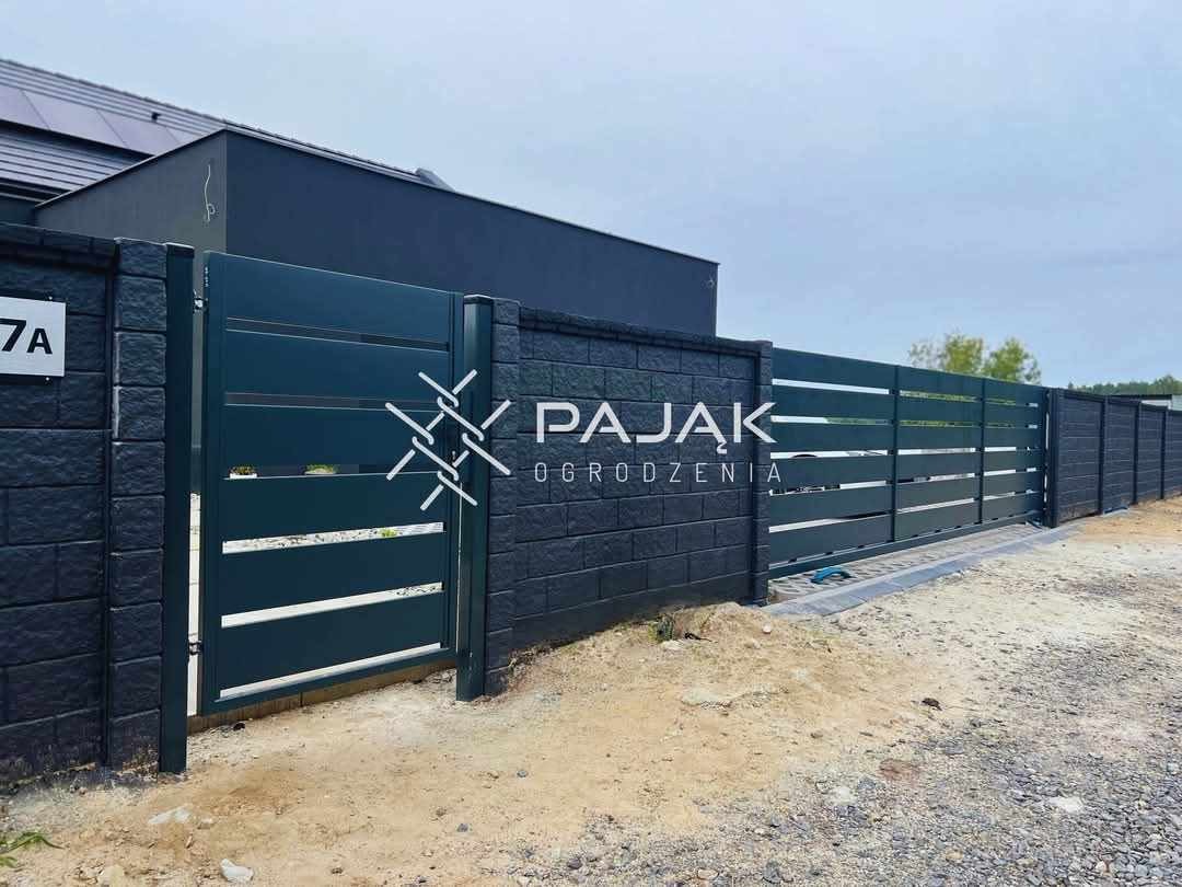 Nowoczesna brama wjazdowa z poziomymi panelami w kolorze grafitowym, osadzona w murze z ciemnej cegły, z widocznym logo firmy 'Pająk Ogrodzenia'.