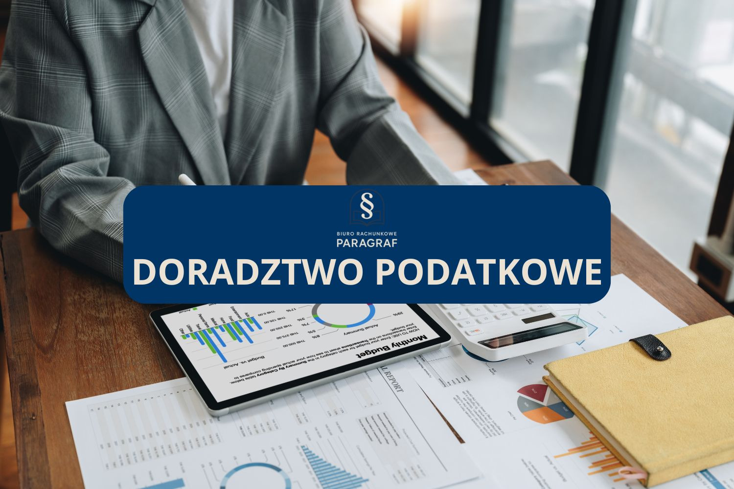 Doradztwo podatkowe w Bydgoszczy: Osoba analizuje dane na tablecie, kalkulator, notatnik i raporty finansowe na biurku. Logo 'Paragraf' biura rachunkowego.