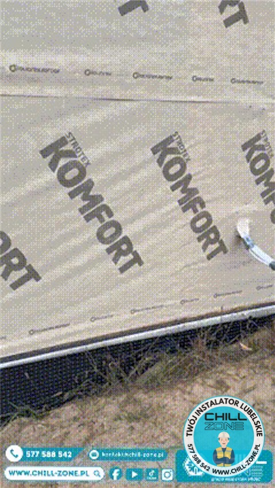 Aplikacja folii paroizolacyjnej Strotex Komfort na ścianę budynku. Widoczny fragment ściany, narzędzie aplikacyjne i logo firmy Chill Zone na dole zdjęcia.