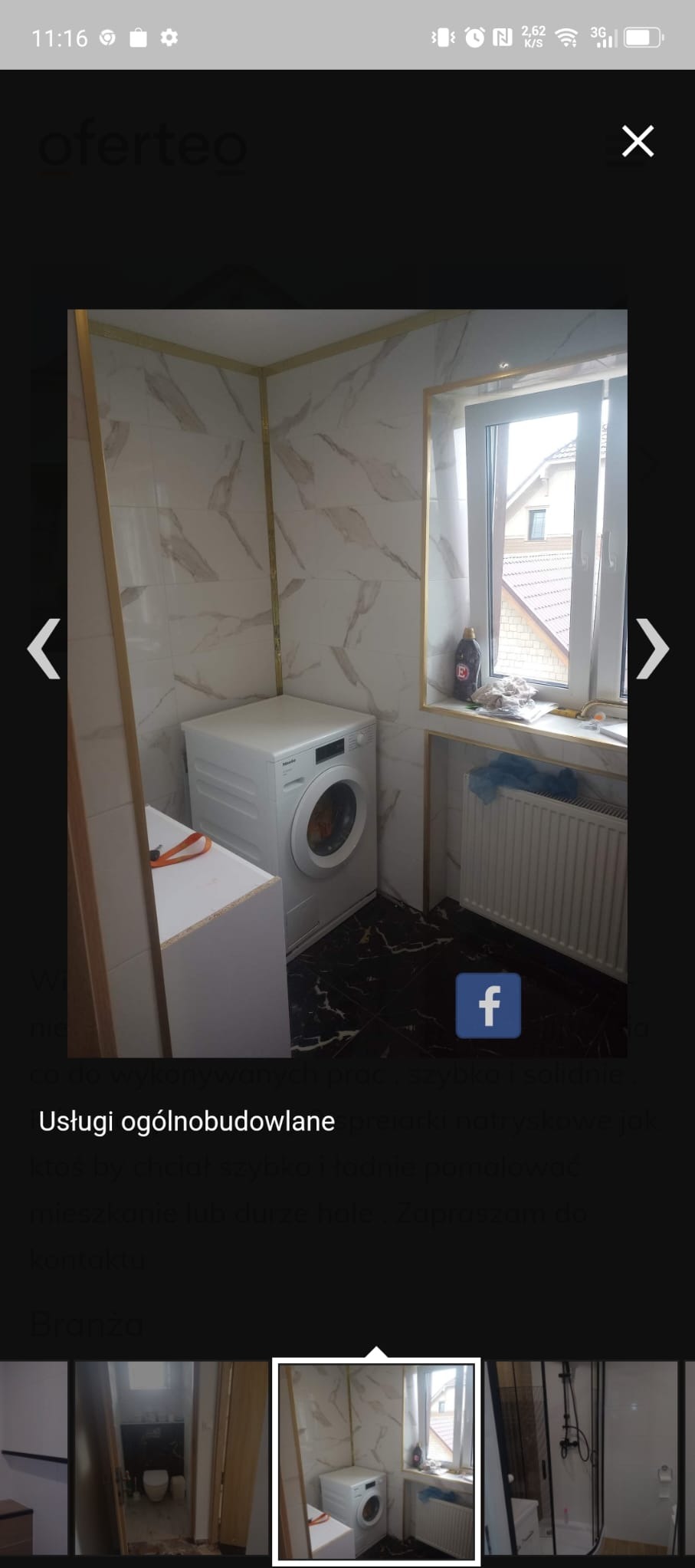 Wyremontowana łazienka z pralką Miele, białe marmurowe płytki z elementami w kolorze złota, czarna marmurowa podłoga, okno z widokiem na dach domu.