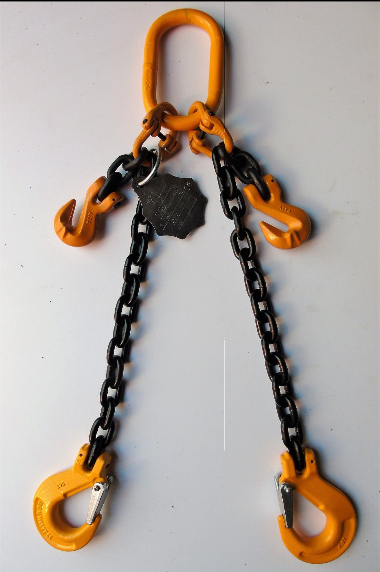 Zawiesie łańcuchowe dwucięgnowe z żółtymi hakami i czarnymi łańcuchami, zawieszone na białym tle, z metalową tabliczką znamionową.