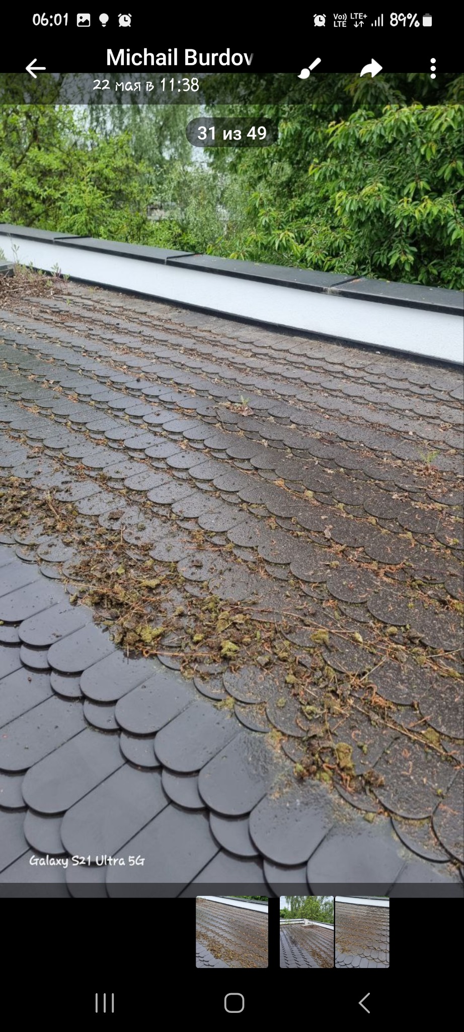 Ciemnoszary dach pokryty okrągłymi dachówkami z widocznymi zabrudzeniami z mchu i liści, wymagający czyszczenia.