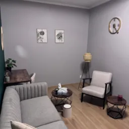 Jasnoszary gabinet z sofą, stolikami kawowymi i lampą podłogową, dekorowany roślinami i obrazkami w ramkach.