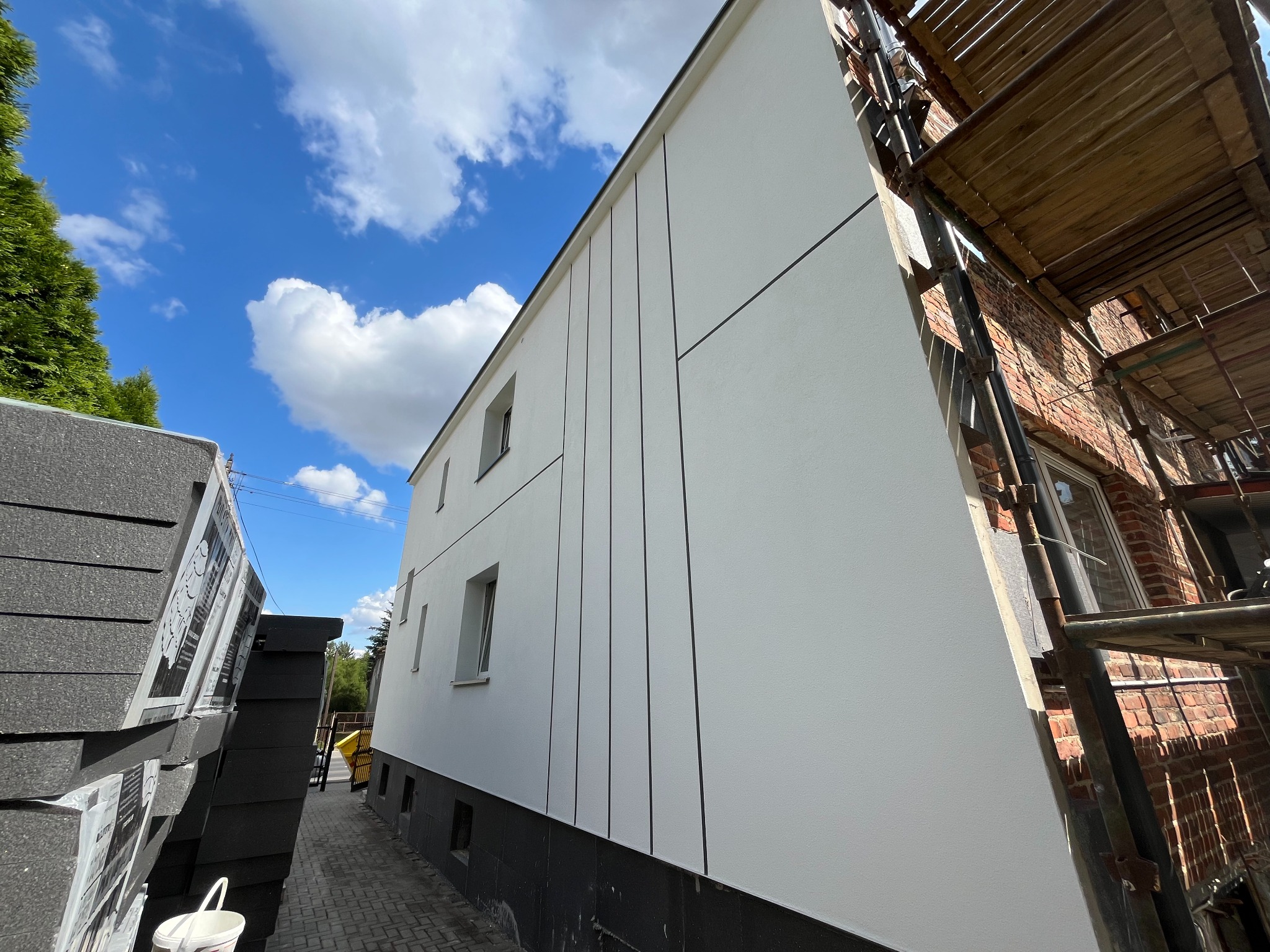 Docieplenie i elewacja - tynk mineralny, pasy malowane farbą silikonową o gładkiej strukturze