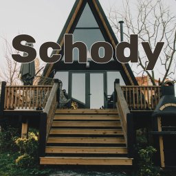 Gardea - Wejście do nowoczesnego domu w kształcie litery A z drewnianym tarasem, schodami i grillem na zewnątrz, widok z dołu na fasadę i otoczenie.