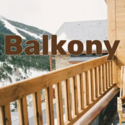 Balkon z drewnianą balustradą i widokiem na ośnieżone góry, z elementami drewnianej konstrukcji budynku i krzesłem w rogu.