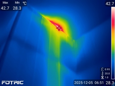 Termowizja: Wykrywanie wycieku ciepła z instalacji. Czerwono-żółta plama na niebieskim tle wskazuje na nieszczelność. Diagnostyka termowizyjna w budownictwie.