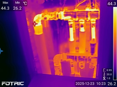 Termowizyjne zdjęcie instalacji hydraulicznej z widocznymi rurami i zaworami, ukazujące rozkład temperatur w systemie. Diagnostyka nieszczelności.
