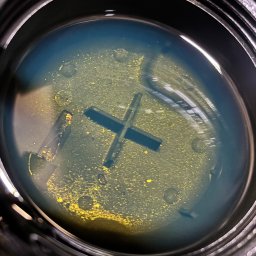 BAI-AUTO Oleksandr Baidiuk - Zbliżenie na wlew zbiornika płynu chłodniczego z widocznym zanieczyszczeniem. Widoczny osad i zmiana koloru płynu. Plastikowy korek wlewu.