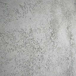 Smart Remonty Wykończenia pod klucz - Szara ściana z wyraźną, nieregularną fakturą, przypominającą efekt dekoracyjnego tynku. Delikatne cieniowanie podkreśla trójwymiarowość powierzchni.