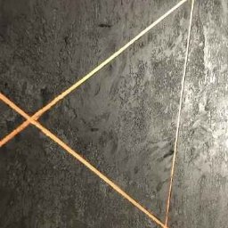 Smart Remonty Wykończenia pod klucz - Dekoracyjna ściana w odcieniach szarości z geometrycznym wzorem z cienkich, złotych linii. Efektowna faktura tynku nadaje wnętrzu nowoczesny charakter.