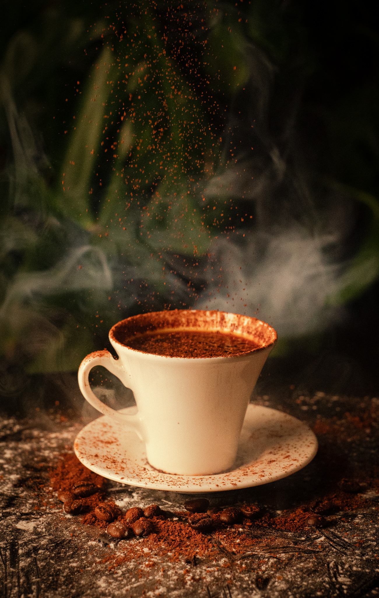 Aromatyczna filiżanka kawy z unoszącym się pyłem kakaowym, otoczona ziarnami kawy i subtelną parą na ciemnym tle.