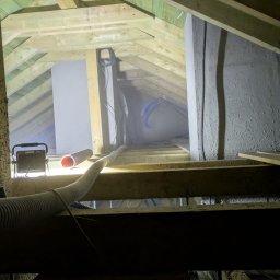 Wdmuchiwanie wełny celulozowej do przestrzeni dachowej poziomej. 