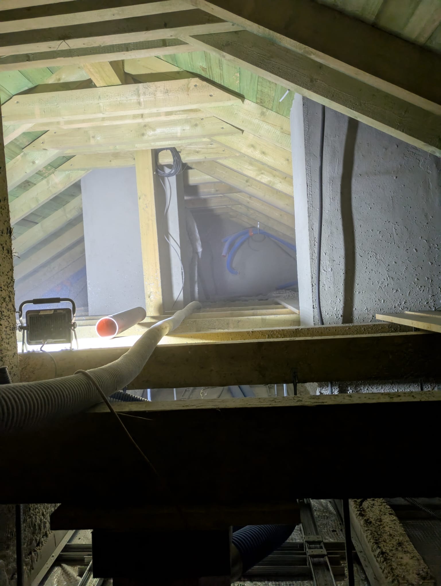 Wdmuchiwanie wełny celulozowej do przestrzeni dachowej poziomej.