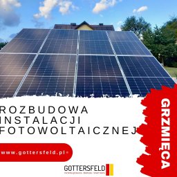 GOTTERSFELD SPÓŁKA Z OGRANICZONĄ ODPOWIEDZIALNOŚCIĄ - Rozbudowa instalacji fotowoltaicznej na dachu domu jednorodzinnego, widok na niebieskie niebo z chmurami, reklama firmy na pierwszym planie.