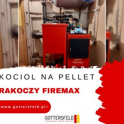 GOTTERSFELD SPÓŁKA Z OGRANICZONĄ ODPOWIEDZIALNOŚCIĄ - Czerwony kocioł na pellet marki Rakoczy Firemax zainstalowany w kotłowni, widoczne rury i osprzęt, obok ściany z haczykami na szczotki do czyszczenia.