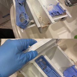 PRACA FKS STAY CLEAN SPÓŁKA Z OGRANICZONĄ ODPOWIEDZIALNOŚCIĄ - Czyszczenie dozownika pralki: ujęcie przed i po. Ręka w niebieskiej rękawiczce trzyma wyczyszczony, błękitny dozownik, w tle umywalka i lustro.