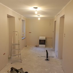 Rafał Lesik MAJSTER LESIK - Wnętrze po malowaniu ścian w Szczedrzyku. Widoczna drabina, odkurzacz przemysłowy i pomalowane ściany na jasny kolor. Przygotowanie do dalszych prac wykończeniowych.
