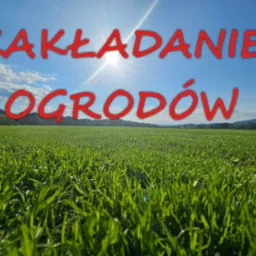 Rozległy trawnik w promieniach słońca pod błękitnym niebem z napisem 'Zakładanie ogrodów' w czerwonej czcionce.