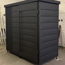 R-Steel Sp. z o.o. - Czarna, metalowa szafa ogrodowa z lamelami po lewej stronie, widoczna w warsztacie.