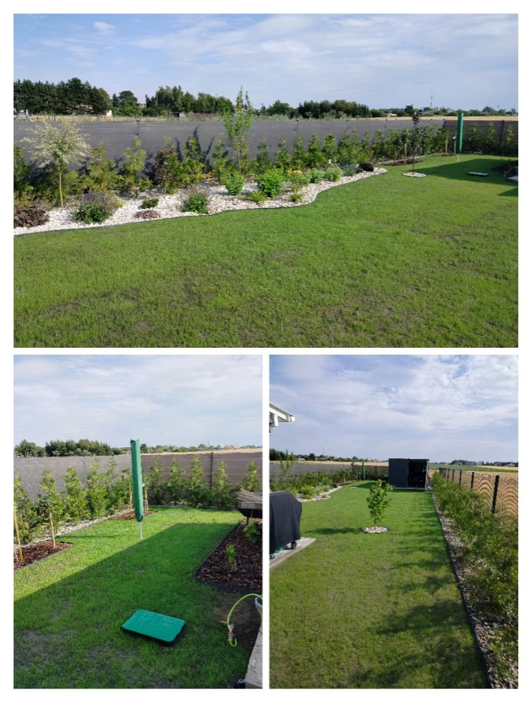 Zadbany ogród z równo przystrzyżonym trawnikiem, rabatami z białym kamieniem i różnorodną roślinnością, ogrodzony siatką z widokiem na okolicę. Słoneczny dzień.