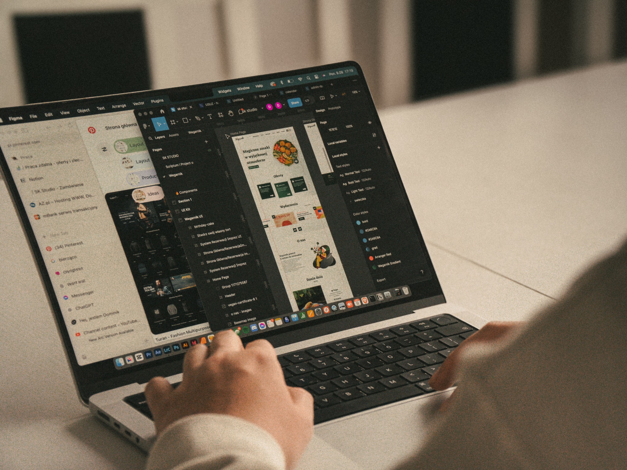 Osoba pracuje na laptopie nad projektem strony internetowej w programie Figma, widoczne elementy interfejsu użytkownika i układ strony z grafiką.