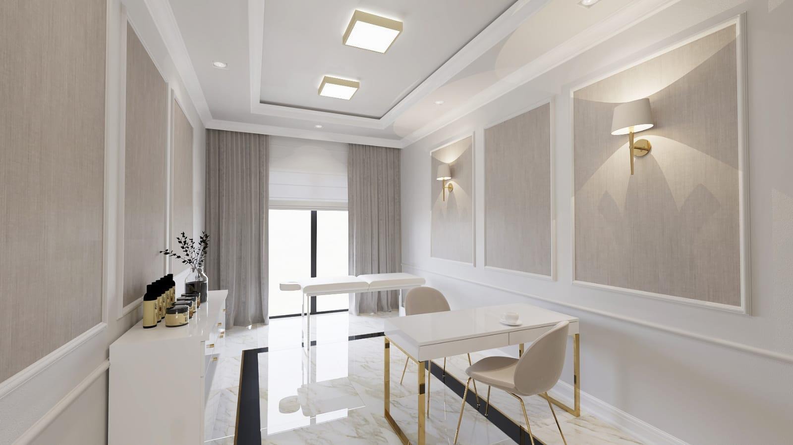 Jasne wnętrze gabinetu kosmetycznego z białym łóżkiem do masażu, biurkiem z kawą, krzesłami na złotych nogach i ścianami zdobionymi kinkietami.