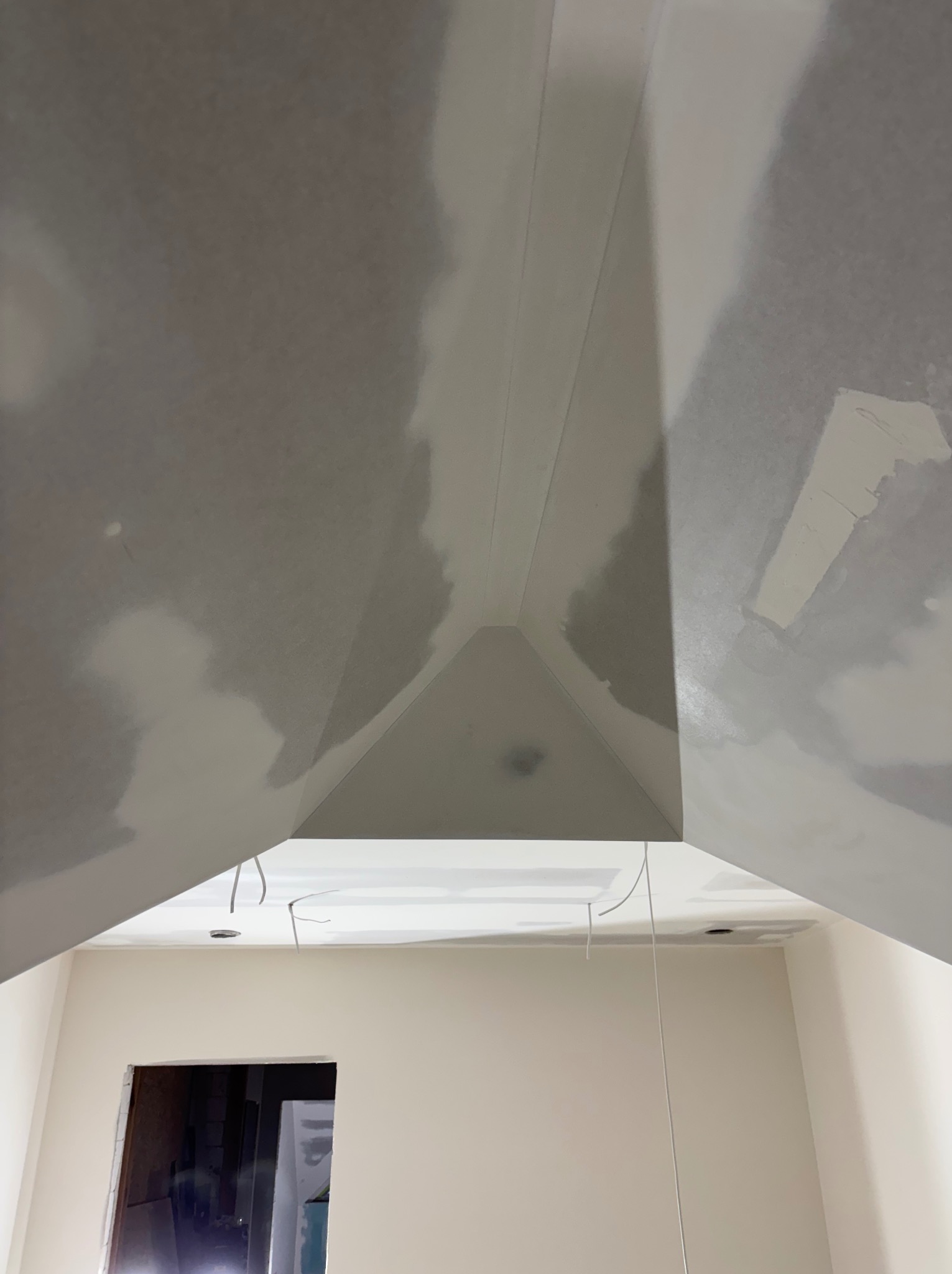 Sufit z płyt gipsowo-kartonowych w trakcie szpachlowania, widoczne kable oświetleniowe. Prace wykończeniowe w Szczepanek.