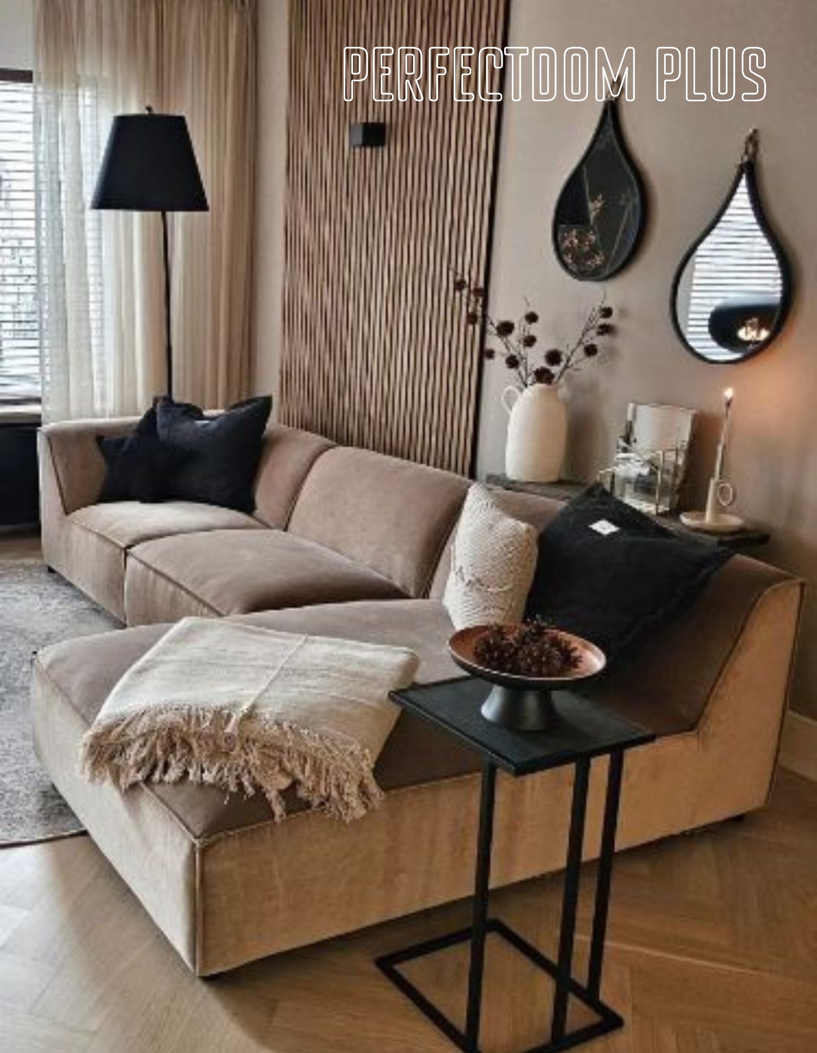 Beżowa, modułowa sofa z czarnymi poduszkami i pledem z frędzlami, ustawiona w salonie z drewnianą ścianą i dekoracyjnymi lustrami w kształcie łezki.