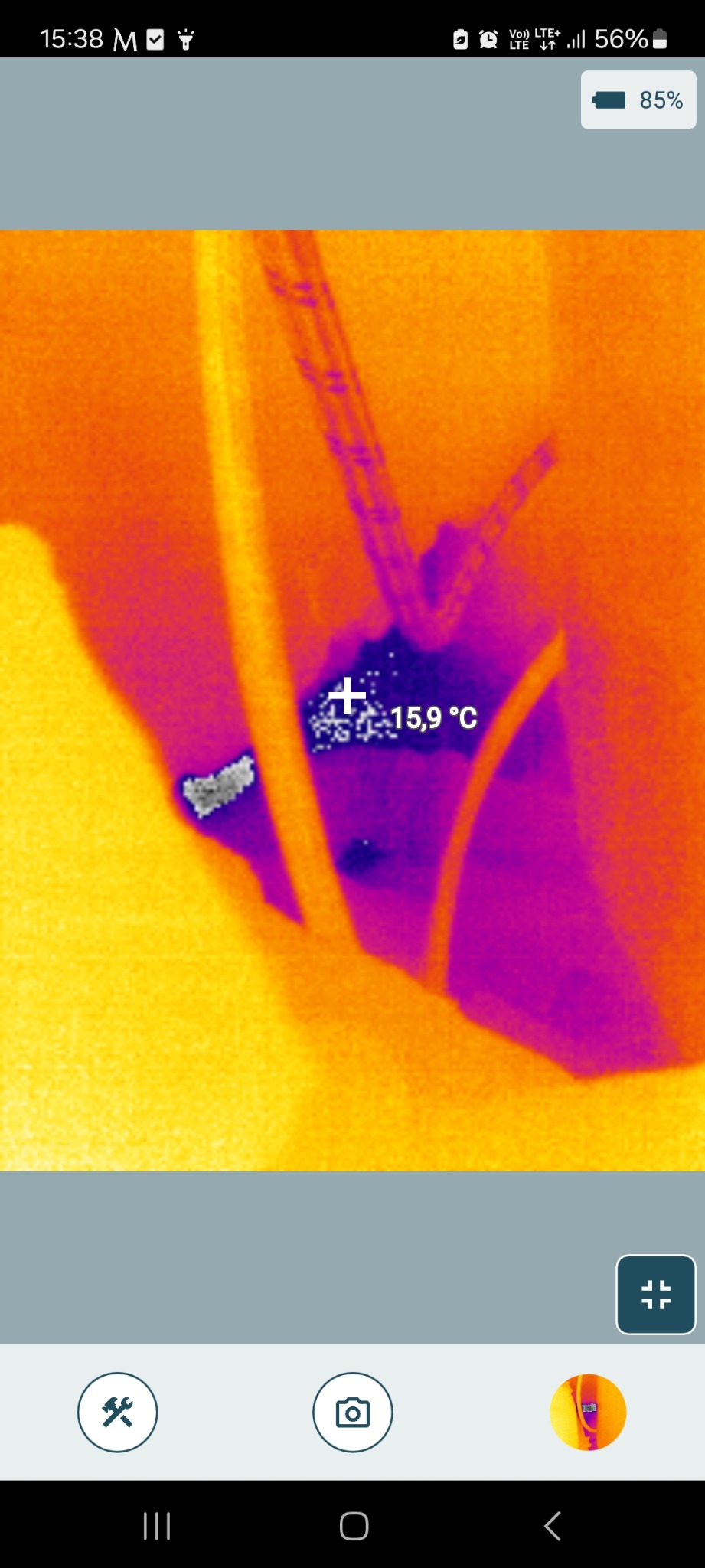 Termowizja rury w ścianie, wskazująca temperaturę 15.9°C. Obraz z kamery termowizyjnej w odcieniach żółci, pomarańczy i fioletu. Diagnostyka instalacji.